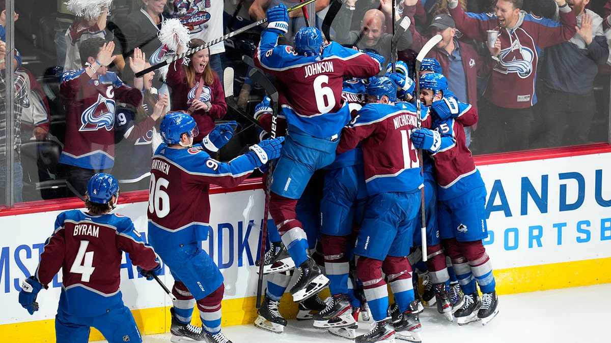 Colorado Avalanche defenseman Cale Makar is swarmed by teammates after scoring against the Nashville Predators during overtime in Game 2 of an NHL hockey Stanley Cup first-round playoff series Thursday, May 5, 2022, in Denver. The Avalanche won 2-1.