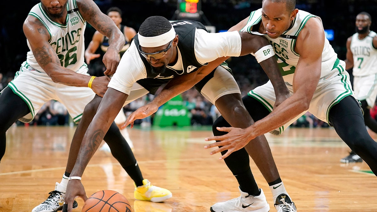 Milwaukee Bucks center Bobby Portis, center, vies for control of the ball with Boston Celtics guard Marcus Smart, left, and center Al Horford, right, during the first half of Game 7 of an NBA basketball Eastern Conference semifinals playoff series, Sunday, May 15, 2022, in Boston.