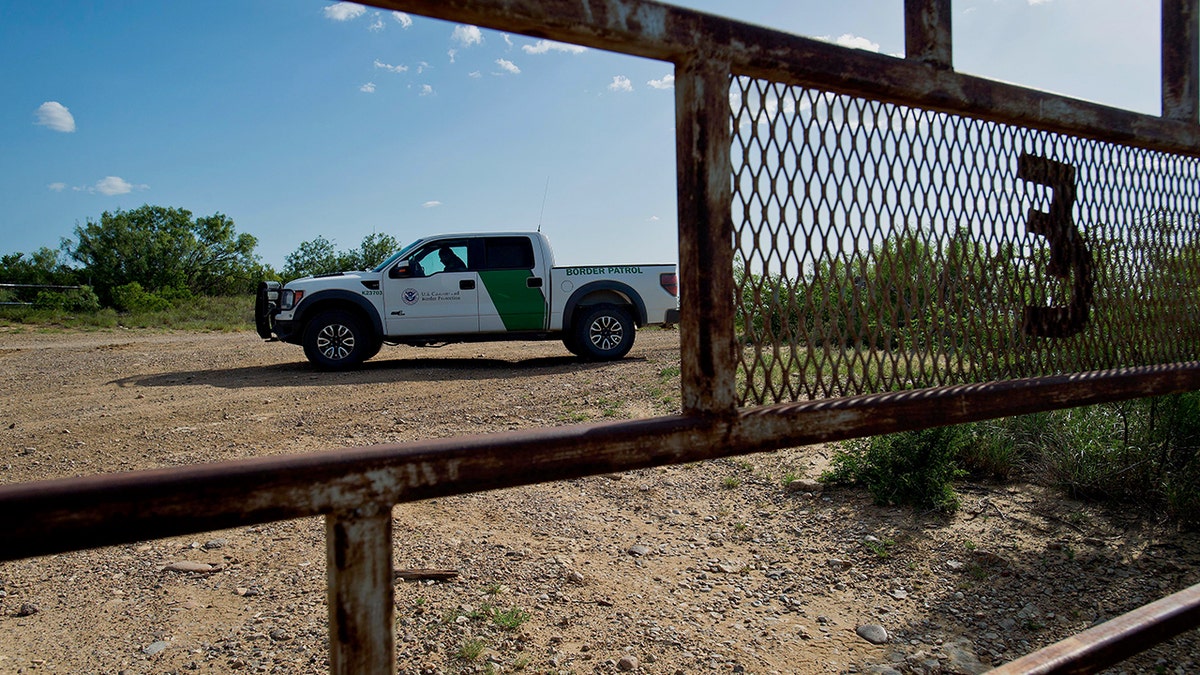 Border Patrol agents behind fence