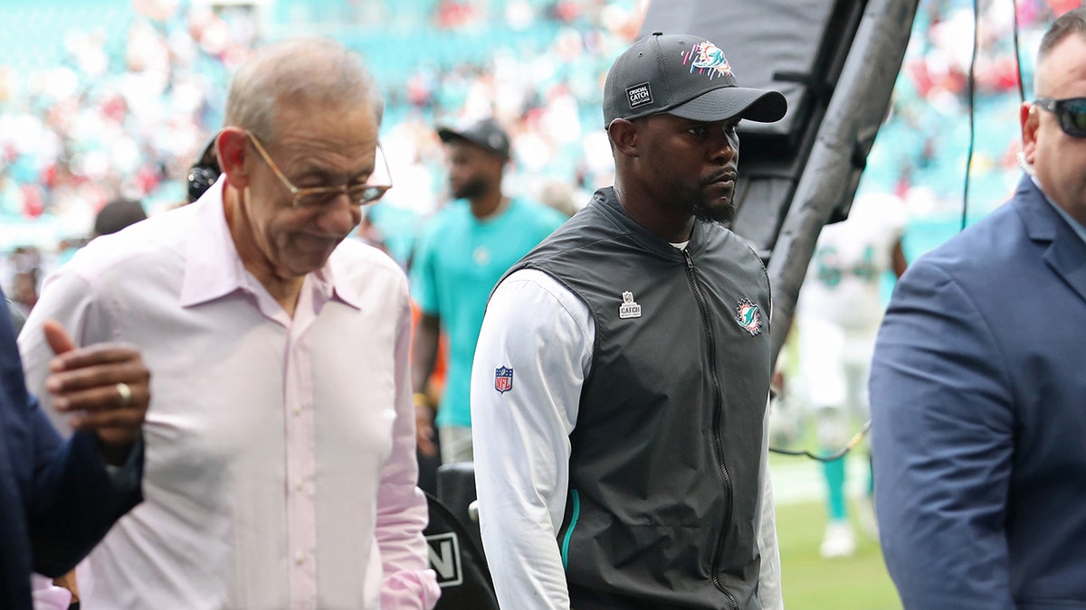 Brian Flores and Stephen Ross walk of the field