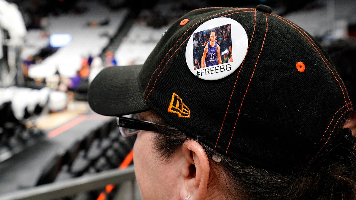 Phoenix Mercury fan Anna Oyerbides wears a "#FreeBG" button referring to  Brittney Griner before a WNBA basketball game between the Mercury and the Las Vegas Aces, Friday, May 6, 2022, in Phoenix.  