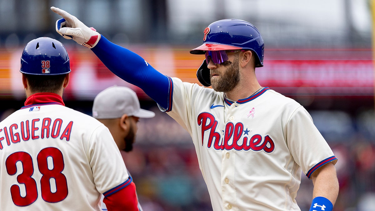 Philadelphia Phillies' Bryce Harper (3) gestures from first base after hitting an RBI single during the third inning of the first game of a double header against the New York Mets, Sunday, May 8, 2022, in Philadelphia.
