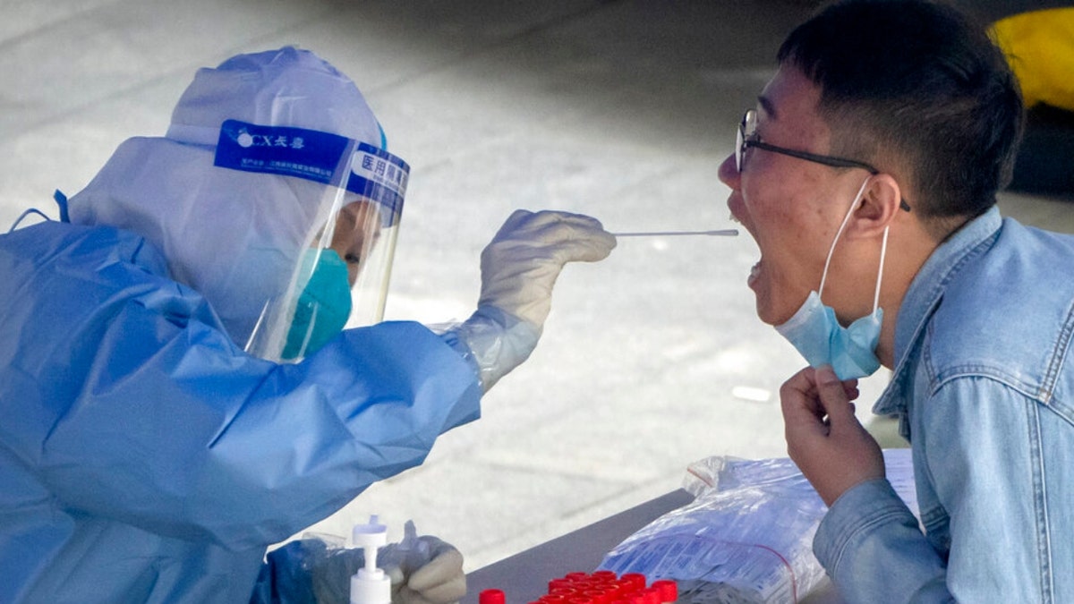 A Beijing man gets a COVID-19 test swab