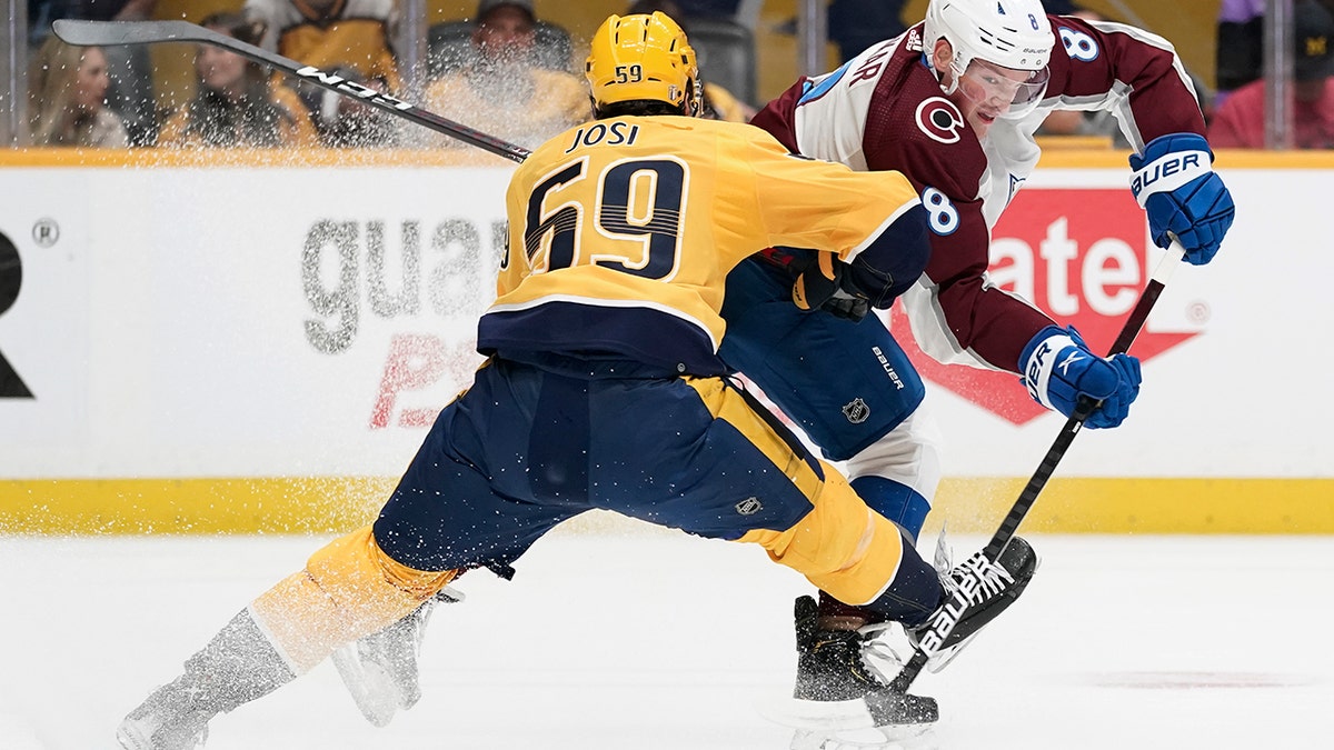 Colorado Avalanche defenseman Cale Makar (8) passes the puck past Nashville Predators' Roman Josi (59) during the first period in Game 4 of an NHL hockey first-round playoff series Monday, May 9, 2022, in Nashville, Tenn. 