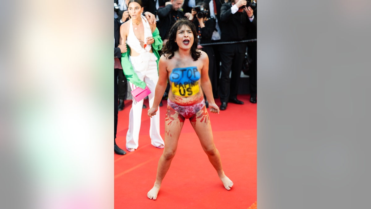 a woman stripped down and exposed a message painted her body on a Cannes Film Festival red carpet