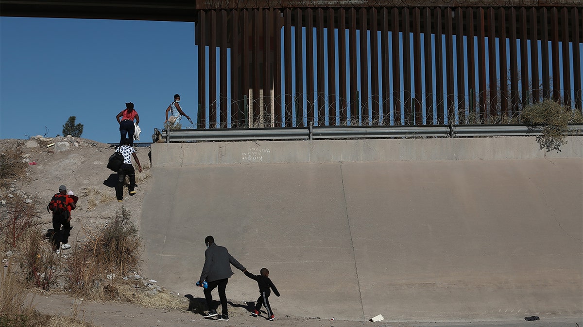 FILE - Haitian families cross the Rio Bravo river illegally to surrender to the American authorities at the border of Mexico's Ciudad Juarez with El Paso, Texas, Dec. 23, 2021, in Ciudad Juarez, Mexico. (Photo by Christian Torres/Anadolu Agency via Getty Images)