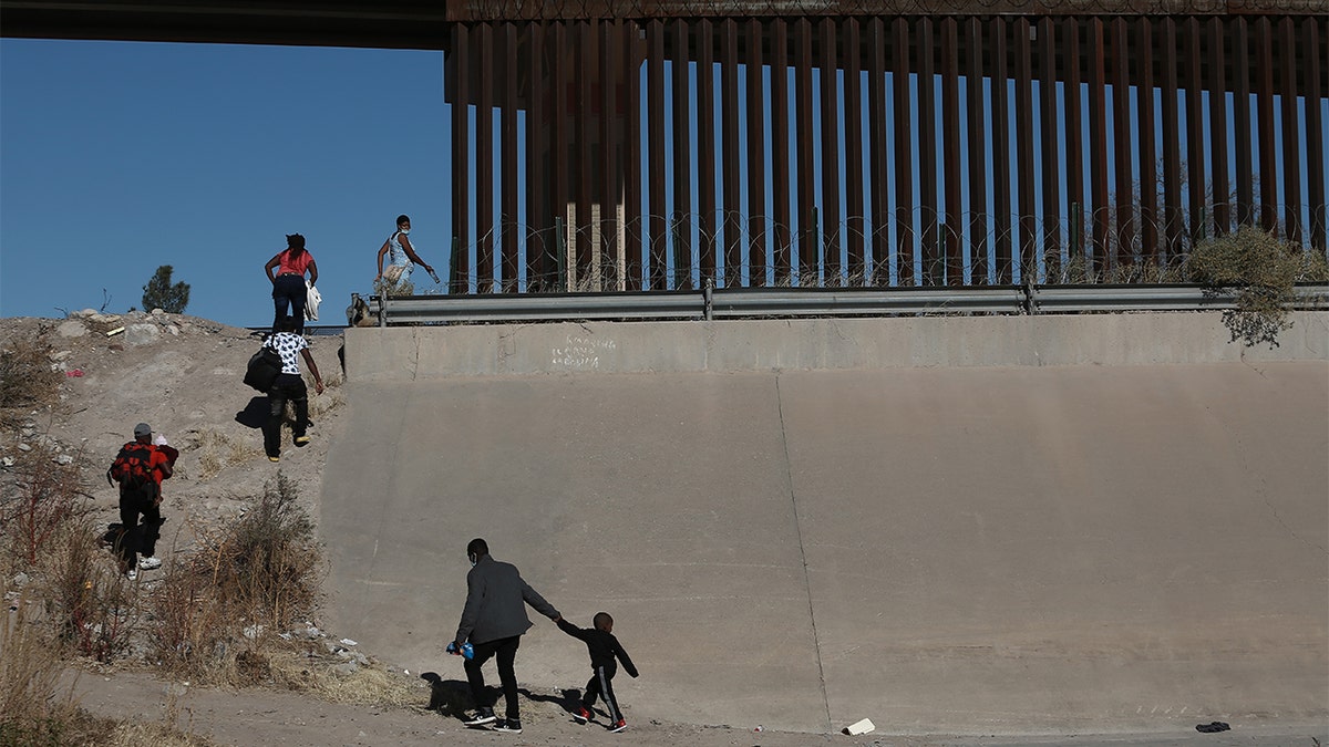 FILE - Haitian families cross the Rio Bravo river illegally