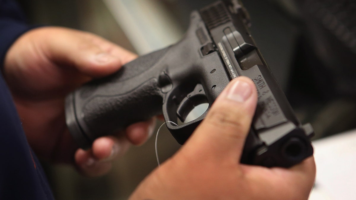 Customer looking at handgun at sporting goods shop