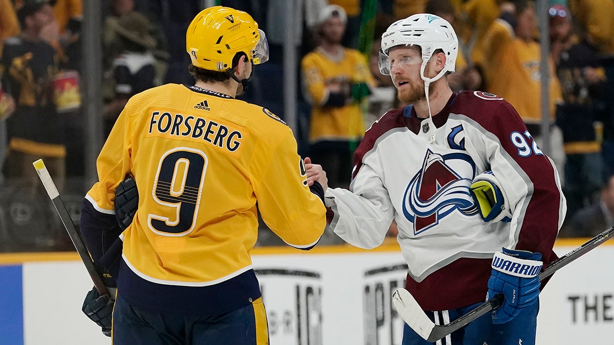 Colorado Avalanche left wing Gabriel Landeskog (92) shakes hands with Nashville Predators' Filip Forsberg (9) after Game 4 of an NHL hockey first-round playoff series Monday, May 9, 2022, in Nashville, Tenn. The Avalanche won 5-3 to sweep the series 4-0.