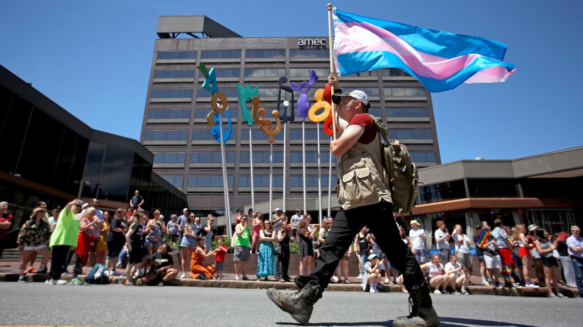 An activist hold a trans pride flag