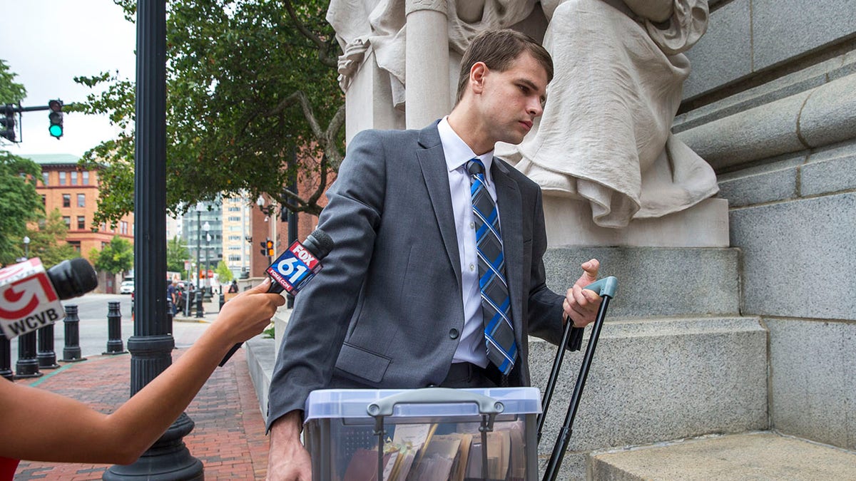 Nathan Carman walking away from reporters.