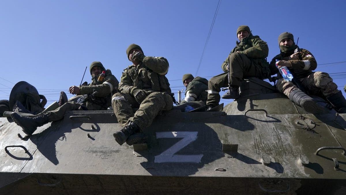 Russian soldiers sit on a tank