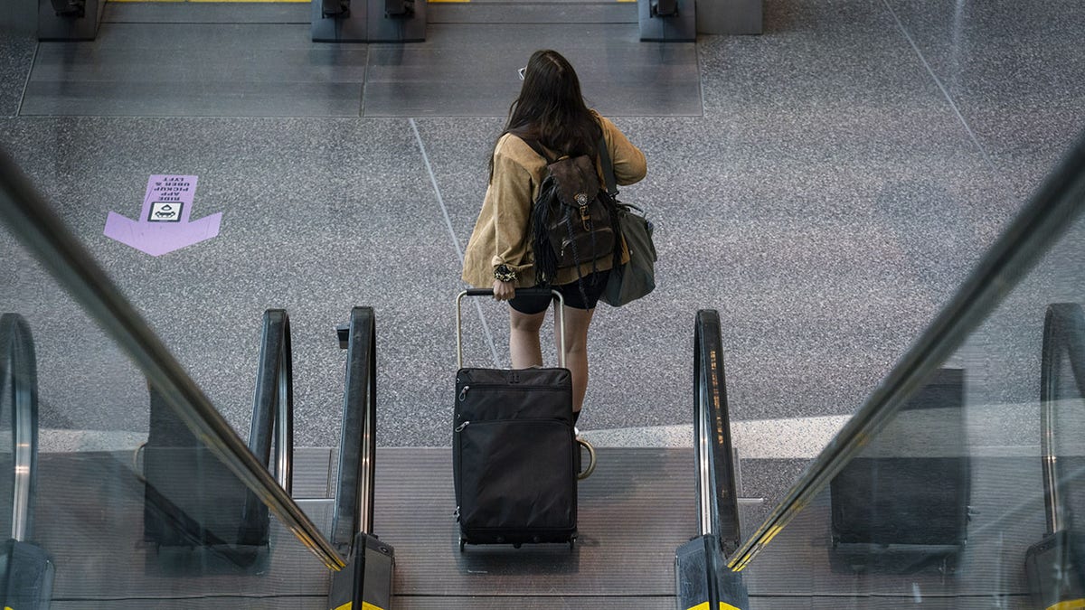 This file image shows a female traveler at Logan International Airport in Boston, Massachusetts, on Thursday, April 21, 2022. 