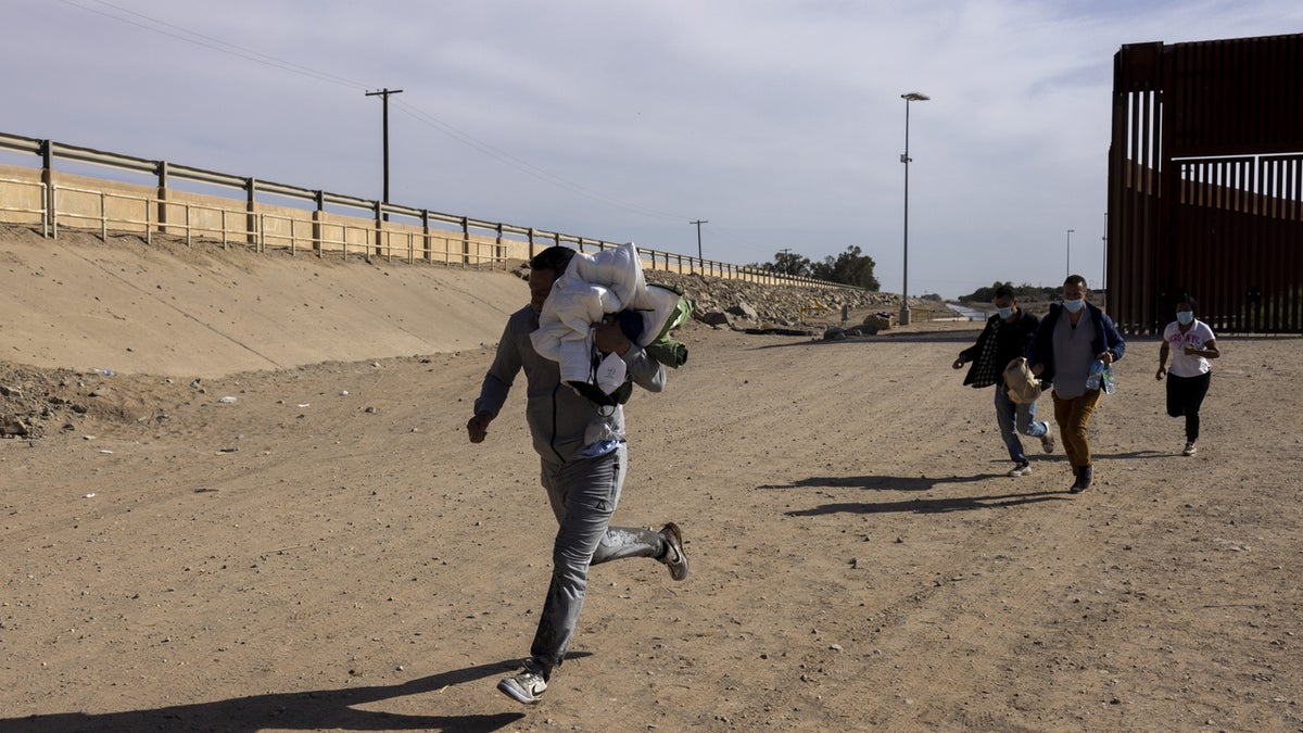 Migrants seeking asylum arrive after crossing the Mexico and U.S. border in Yuma, Arizona, U.S. on Tuesday, May 3, 2022. The U.S. immigration system would come under intense pressure if the end of a fast-track deportation policy triggers a surge of as many as 18,000 migrants at the southern border,