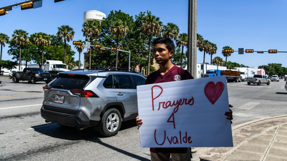 Resident holds sign saying 'Prayers 4 Uvalde'