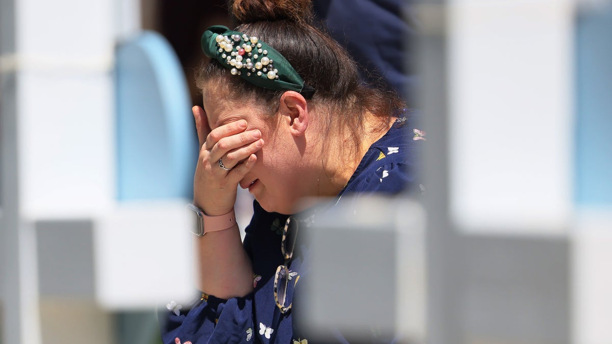 A woman cries before a memorial in Uvalde, Texas