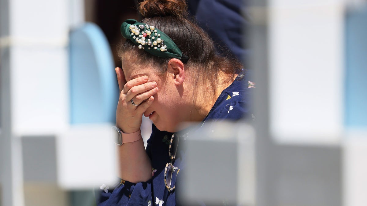 A woman cries before a memorial