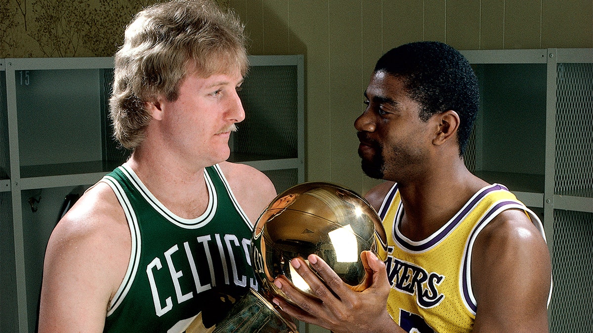 Larry Bird #33 of the Boston Celtics poses for a portrait with Magic Johnson of the Los Angeles Lakers with each holding the NBA Championship Trophy at The Great Western Forum in Los Angeles, California.