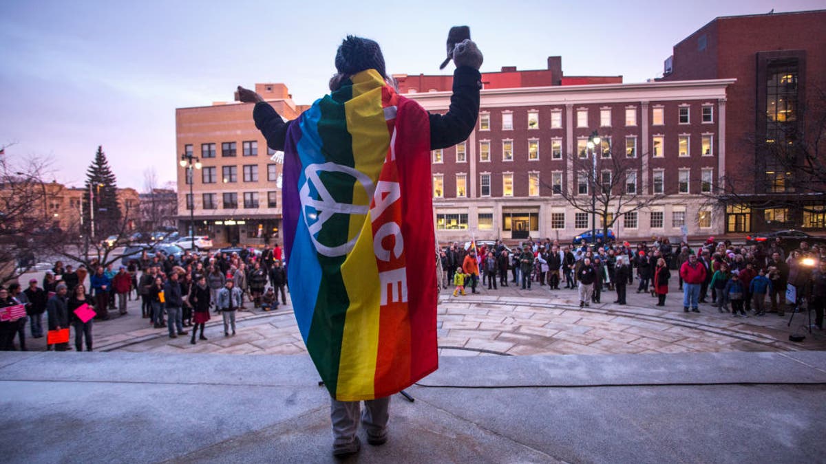 An LGBT activist speaks to a large crowd