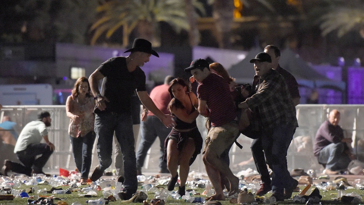 Concertgoers rush to save a victim at the Route 91 Harvest country music festival at the Las Vegas Village on October 1, 2017 in Las Vegas, Nevada.