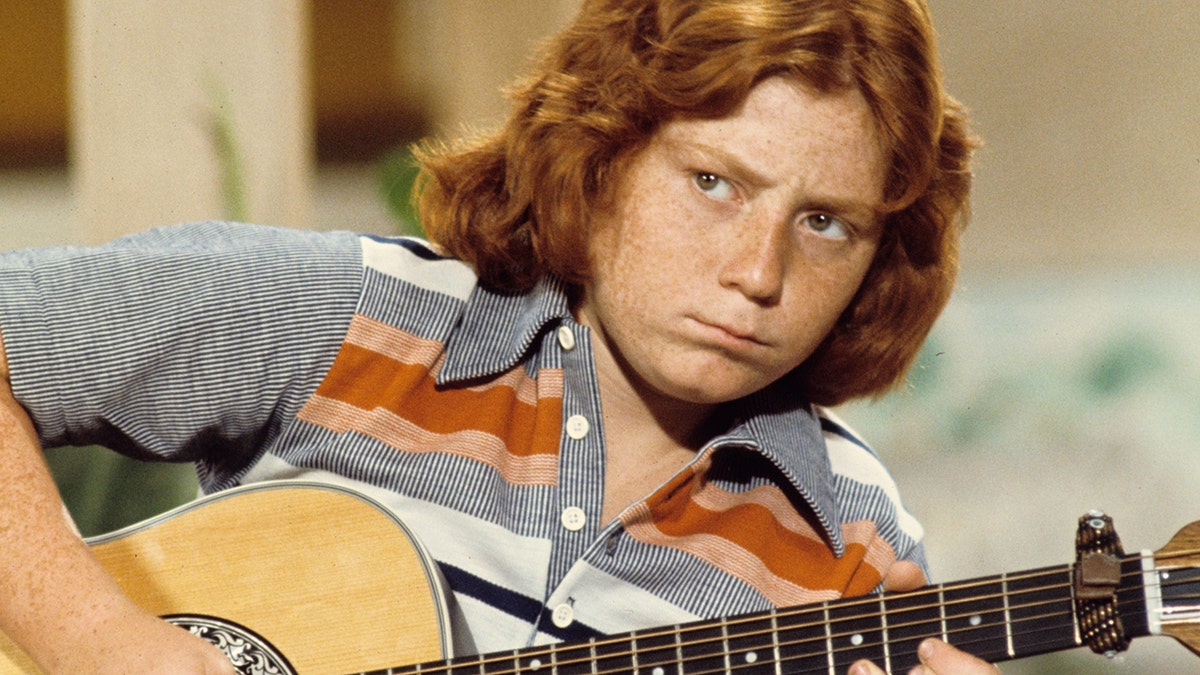 Danny Bonaduce strums a guitar on The Partidge Family