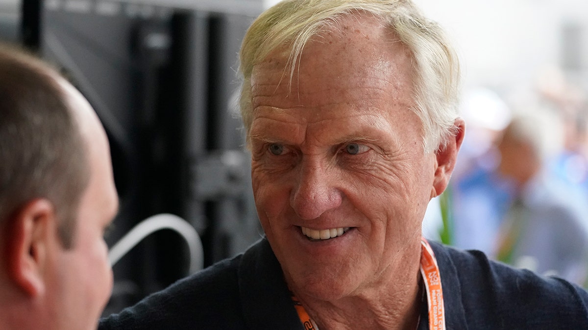 Professional golfer Greg Norman walks through the pit area during the third practice session for the Formula One Miami Grand Prix auto race at the Miami International Autodrome, Saturday, May 7, 2022, in Miami Gardens, Fla.