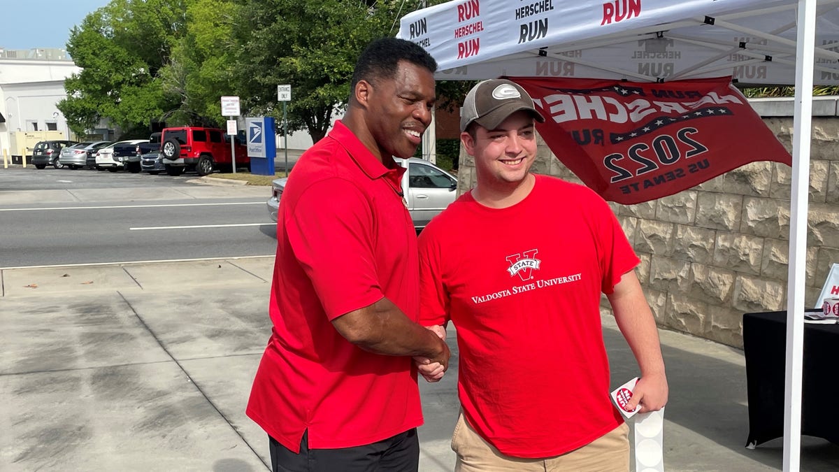 Republican Senate candidate Herschel Walker shakes hands with a supporter at a campaign event in Valdosta, Georgia, on May 21, 2022