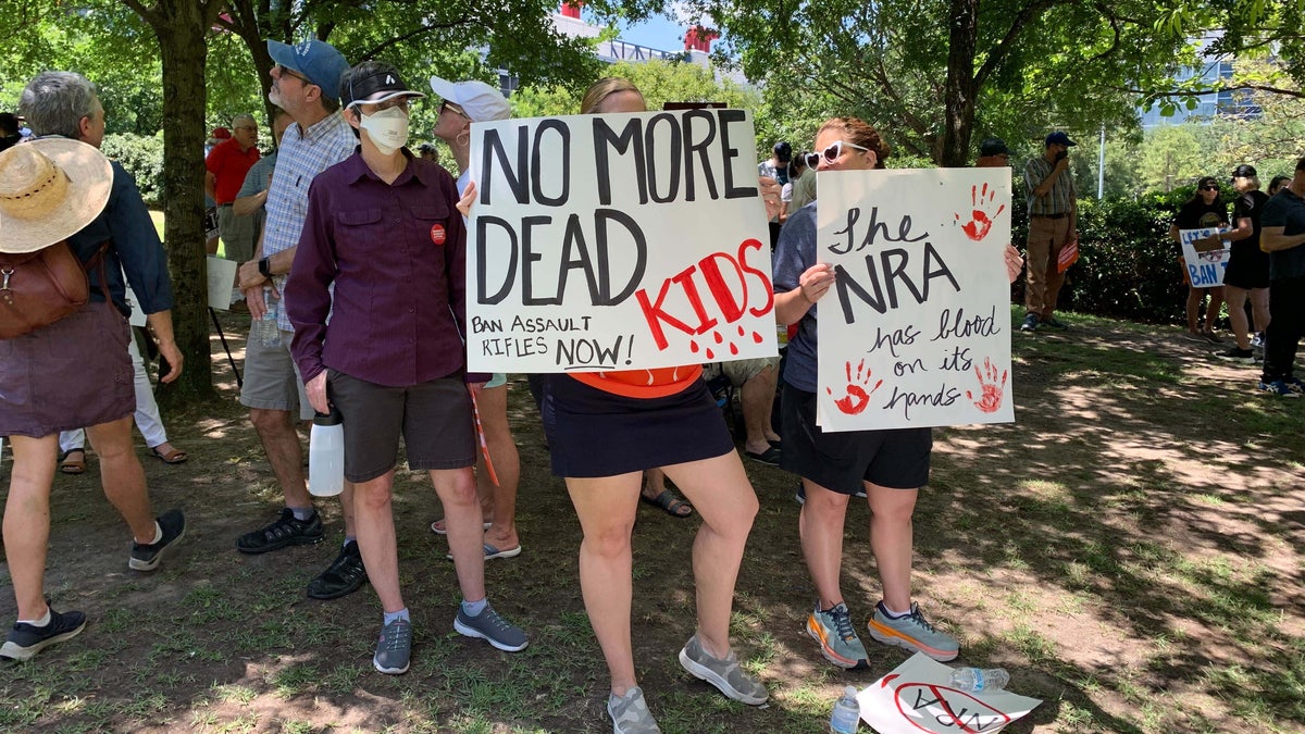 A group stands holding anti-gun signs