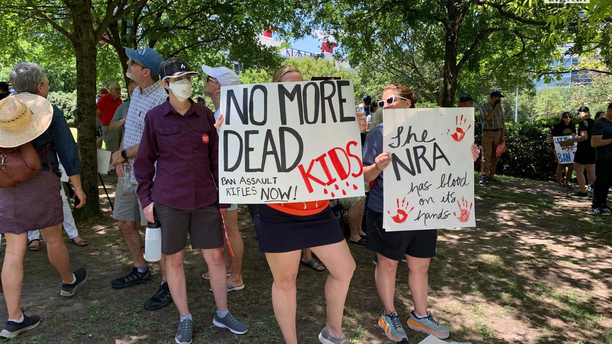 A group stands holding anti-gun signs