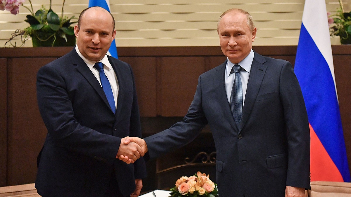 Russian President Vladimir Putin shakes hands with Israeli Prime Minister Naftali Bennett during their meeting, in Sochi, on Oct. 22 2021. (Photo by YEVGENY BIYATOV/Sputnik/AFP via Getty Images)