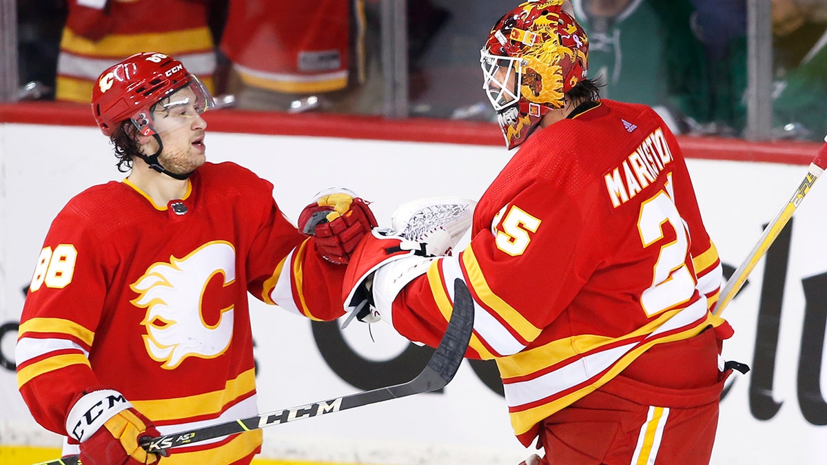 Calgary Flames left wing Andrew Mangiapane (88) and goaltender Jacob Markstrom (25) celebrate defeating the Dallas Stars in Game 5 of an NHL hockey Stanley Cup first-round playoff series, Wednesday, May 11, 2022 in Calgary, Alberta. 