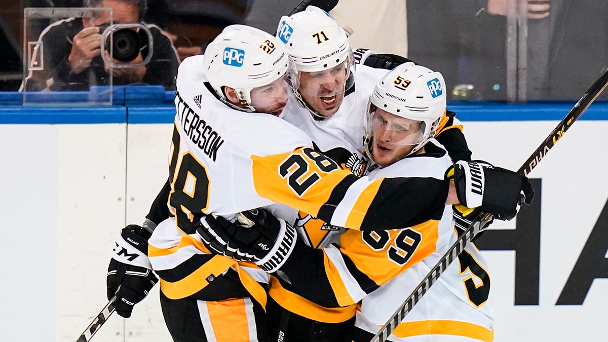 Pittsburgh Penguins' Jake Guentzel (59) celebrates with teammates Marcus Pettersson (28) and Evgeni Malkin (71) after scoring a goal during the second period of Game 5 of an NHL hockey Stanley Cup first-round playoff series against the New York Rangers Wednesday, May 11, 2022, in New York.