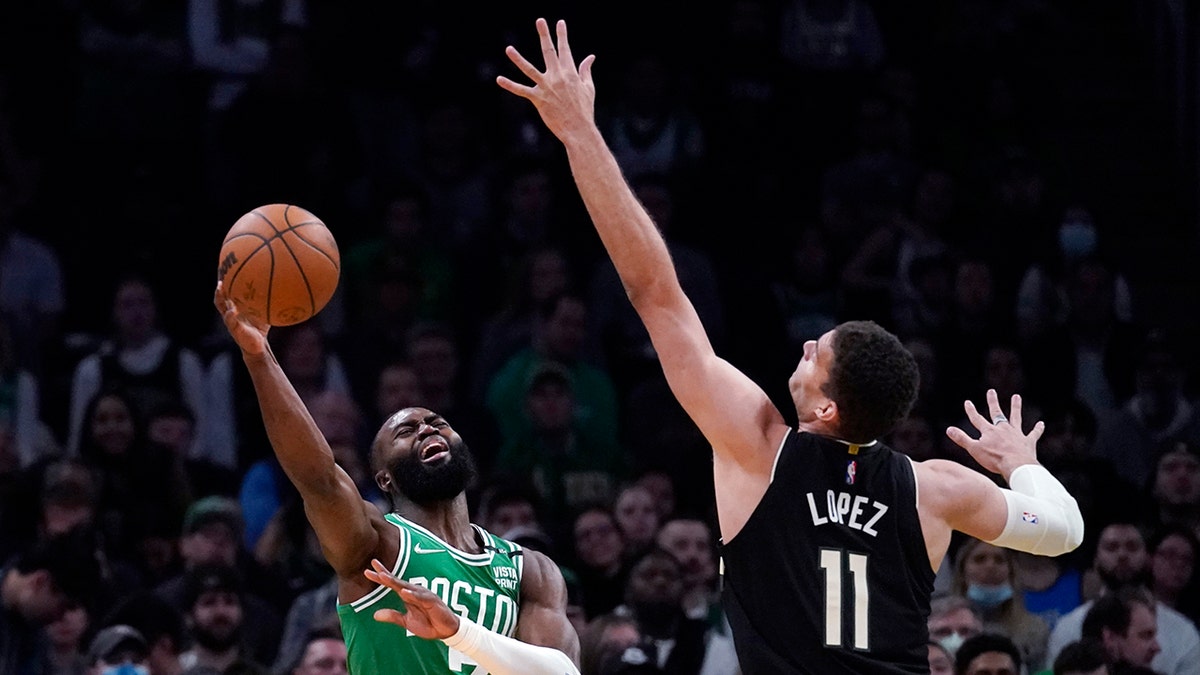 Boston Celtics guard Jaylen Brown, left, shoots while pressured by Milwaukee Bucks center Brook Lopez (11) during the first half of Game 2 of an Eastern Conference semifinal in the NBA basketball playoffs Tuesday, May 3, 2022, in Boston.