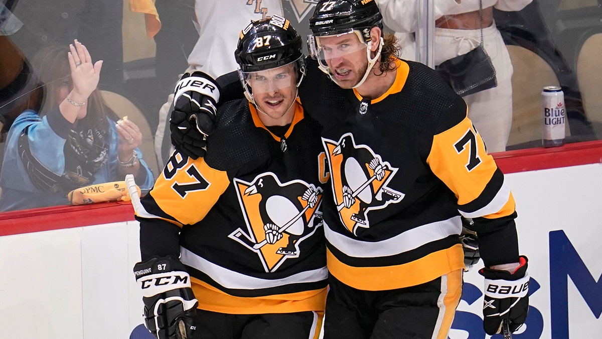 Pittsburgh Penguins' Jeff Carter (77) celebrates his second goal, an empty-net goal during the third period, with Sidney Crosby in Game 3 of an NHL hockey Stanley Cup first-round playoff series against the New York Rangers in Pittsburgh, Saturday, May 7, 2022. 