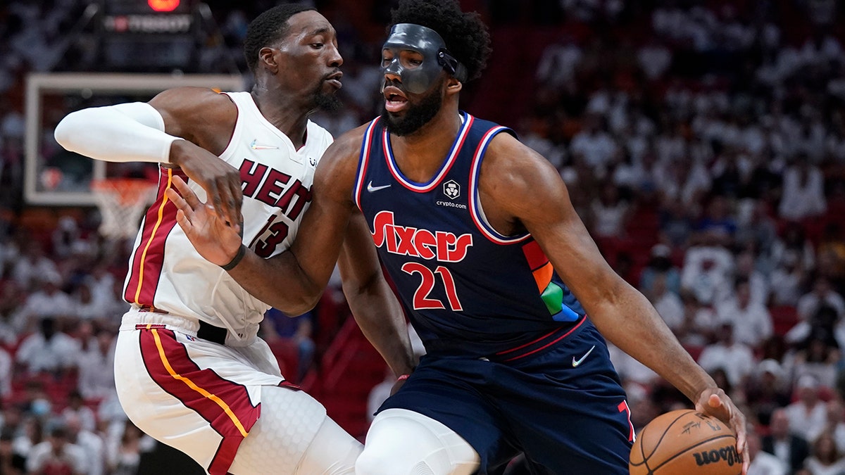 Philadelphia 76ers center Joel Embiid (21) drives up against Miami Heat center Bam Adebayo (13) during the first half of Game 5 of an NBA basketball second-round playoff series, Tuesday, May 10, 2022, in Miami.