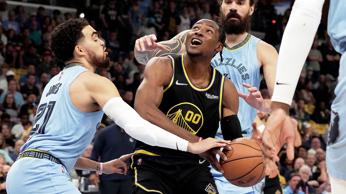 Golden State Warriors' Jonathan Kuminga (00) goes up for a basket as Memphis Grizzlies' Tyus Jones (21) defends in the first half of Game 5 of an NBA basketball second-round playoff series Wednesday, May 11, 2022, in Memphis, Tenn. 