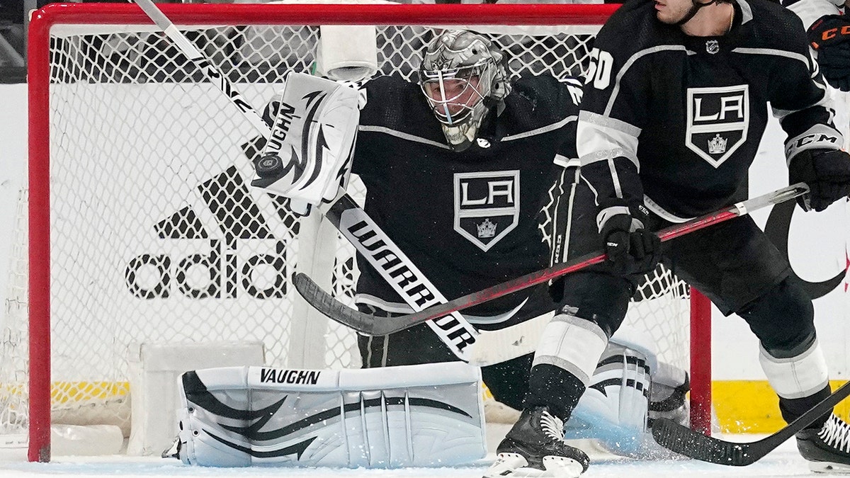 Los Angeles Kings goaltender Jonathan Quick, left, makes a pad save as defenseman Sean Durzi watches during the second period in Game 4 of an NHL hockey Stanley Cup first-round playoff series against the Edmonton Oilers Sunday, May 8, 2022, in Los Angeles. 