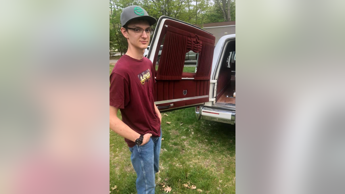 Eighteen-year-old Levi Caverly stands in front of a truck