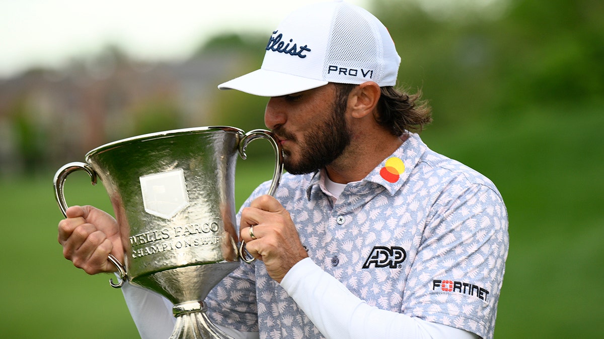 Max Homa kisses the trophy after winning the Wells Fargo Championship golf tournament, Sunday, May 8, 2022, at TPC Potomac at Avenel Farm golf club in Potomac, Md. 