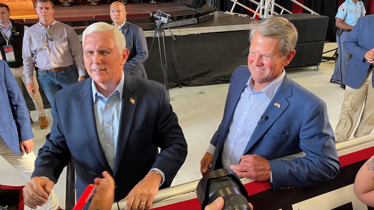 Former Vice President Mike Pence and Republican Gov. Brian Kemp of Georgia shake hands with supporters after Pence headlined a primary eve rally for Kemp, on May 23, 2022 in Cobb County, Georgia 