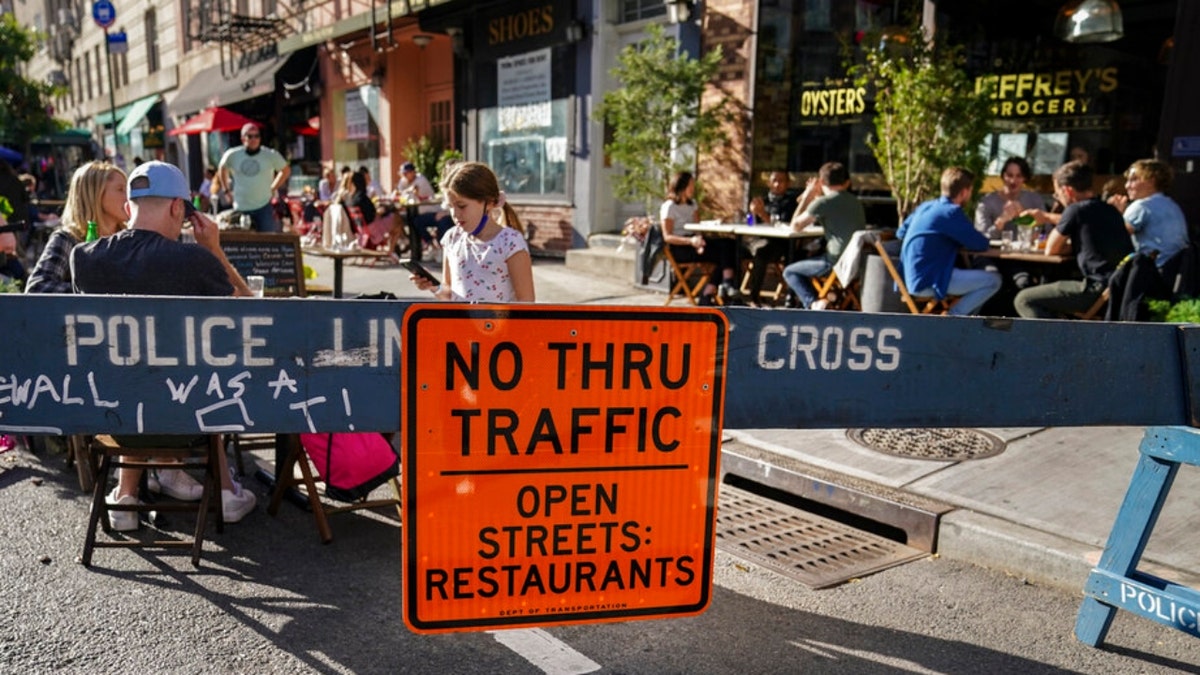 FILE - Diners sit outside restaurants operating outdoor spaces that spread onto sidewalks and streets as part of continued COVID-19 economic impact mitigation efforts, Saturday, Oct. 3, 2020, in New York.?