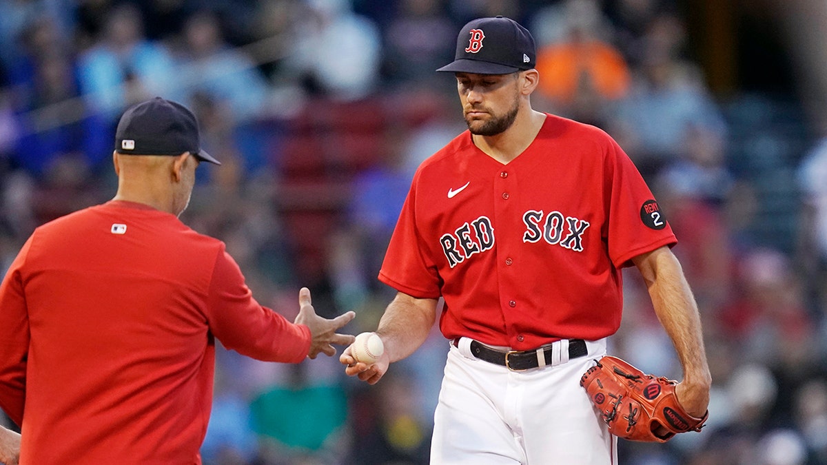 Boston Red Sox starting pitcher Nathan Eovaldi, right, hands the ball to manager Alex Cora during the second inning of the team's baseball game against the Houston Astros at Fenway Park, Tuesday, May 17, 2022, in Boston. Eovaldi allowed nine runs, six earned, in the second inning.?