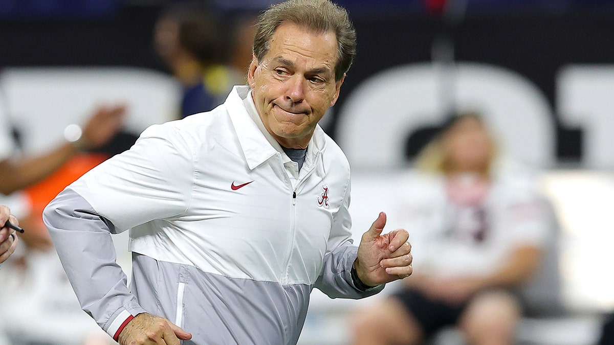 Alabama's Nick Saban leads his team onto the field