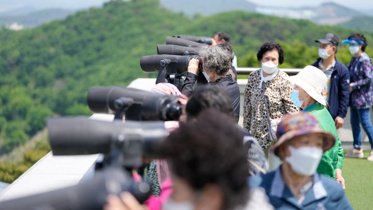 Visitors use binoculars to see the North Korean side from the unification observatory in Paju, South Korea, Thursday, May 12, 2022. (AP Photo/Lee Jin-man)