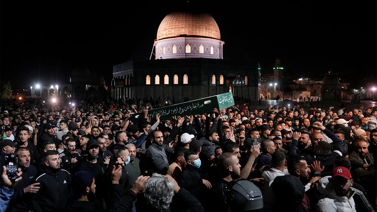 Mourners carry the coffin of Palestinian, Waleed Shareef, 21, during his funeral at the Al Aqsa Mosque compound in Jerusalem's Old City, Monday, May 16, 2022. Shareef died Saturday from a head wound sustained last month after Israeli police fired rubber bullets at stone-throwing Palestinian demonstrators during violence at the Al Aqsa Mosque compound, in Jerusalem's Old City. (AP Photo/Mahmoud Illean)