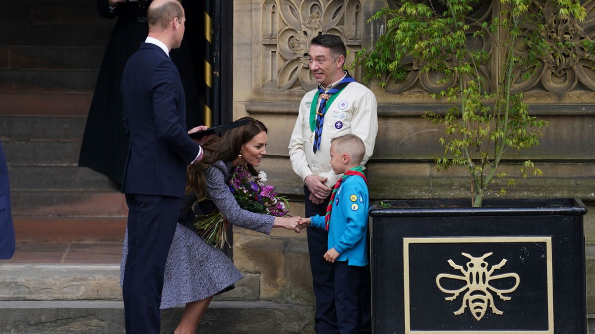 William and Middleton speak to Archie McWilliams, aged 7, from the First Longford Scout Group in Stretford, and his uncle Greater Manchester West Scouts' County Commissioner Andy Farrell, as they leave after attending the launch of the Glade of Light Memorial, outside Manchester Cathedral.