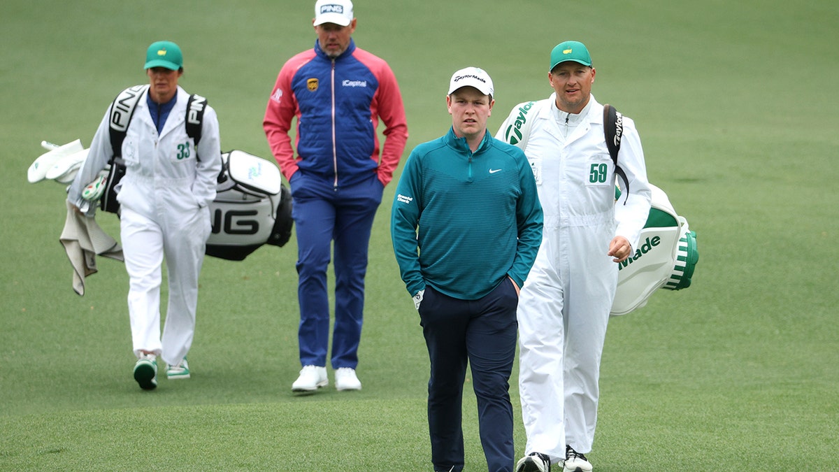 The group of Lee Westwood of England (L) and Robert MacIntyre of Scotland walks across the second hole during the third round of the Masters at Augusta National Golf Club on April 9, 2022 in Augusta, Georgia.
