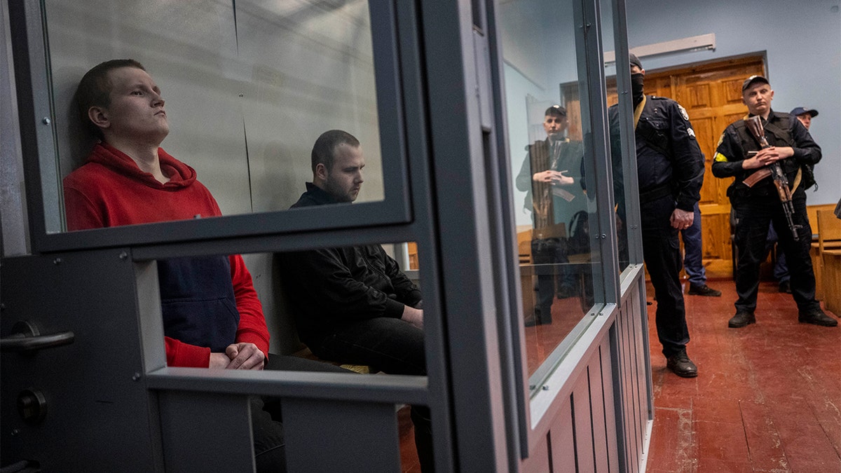 Russian soldiers attend a war crimes hearing