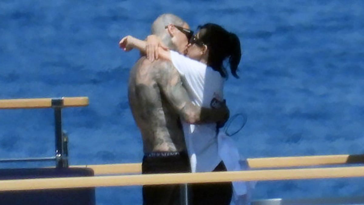 Kourtney Kardashian and Travis Barker kiss on a boat in Portofino