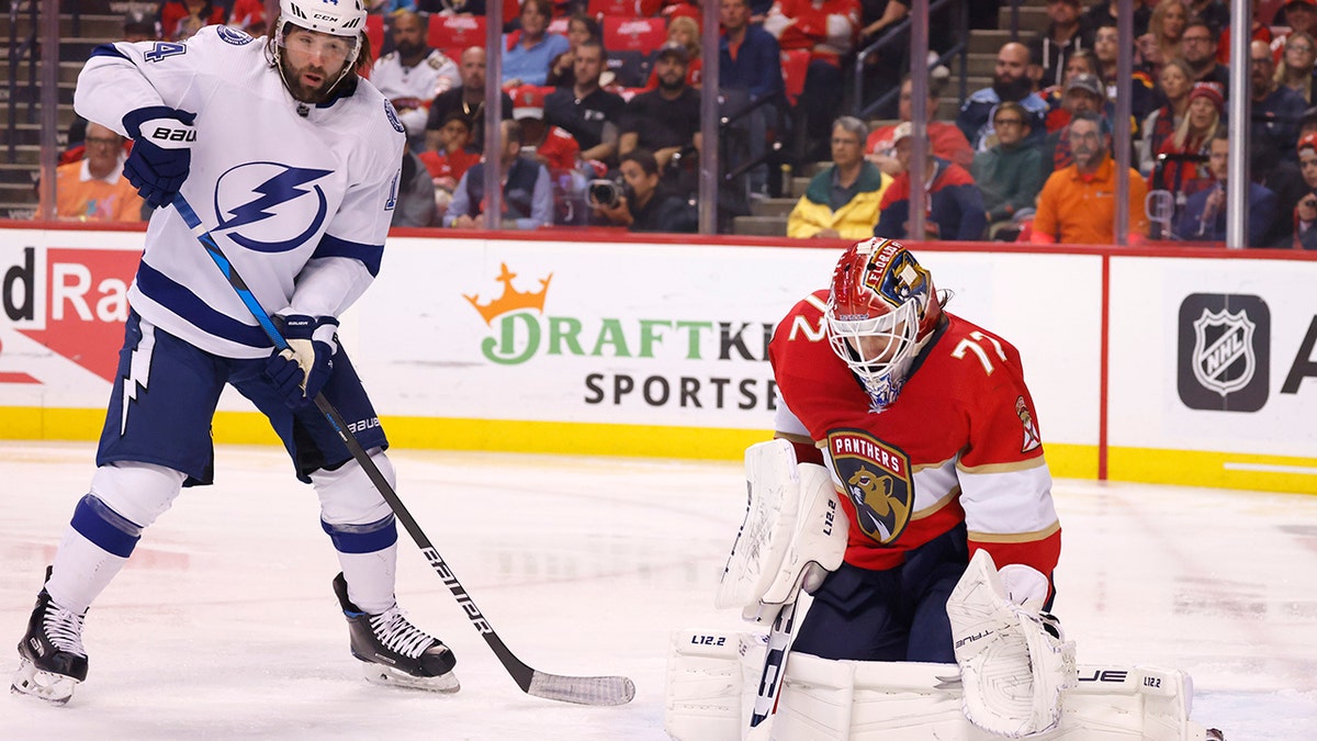 Florida Panthers goaltender Sergei Bobrovsky (72) makes a save as Tampa Bay Lightning left wing Pat Maroon (14) looms overhead during the first period of Game 1 of an NHL hockey second-round playoff series Tuesday, May 17, 2022, in Sunrise, Fla.